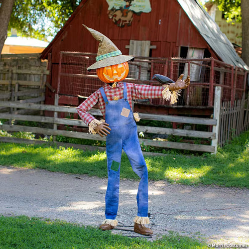 Six-foot Whimsical Scarecrow animatronic with pumpkin head and crow in a harvest display